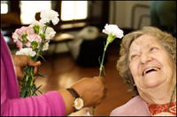 Someone giving an elderly woman a flower photo